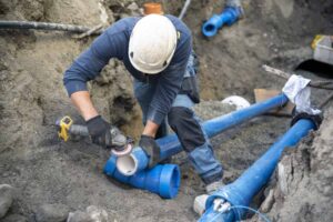 Garon T technician in PPE working on sewer repairs