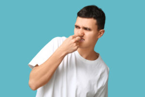 person pinching their nose near a bathroom sink